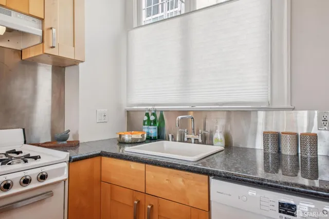 a kitchen with stainless steel appliances granite countertop a sink stove and cabinets