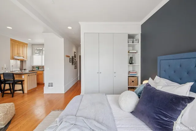 a bedroom with a bed and a view of kitchen