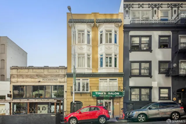 a front view of a building with lot of cars parked