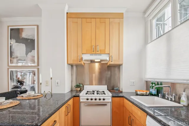 a kitchen with stainless steel appliances granite countertop a sink stove and cabinets
