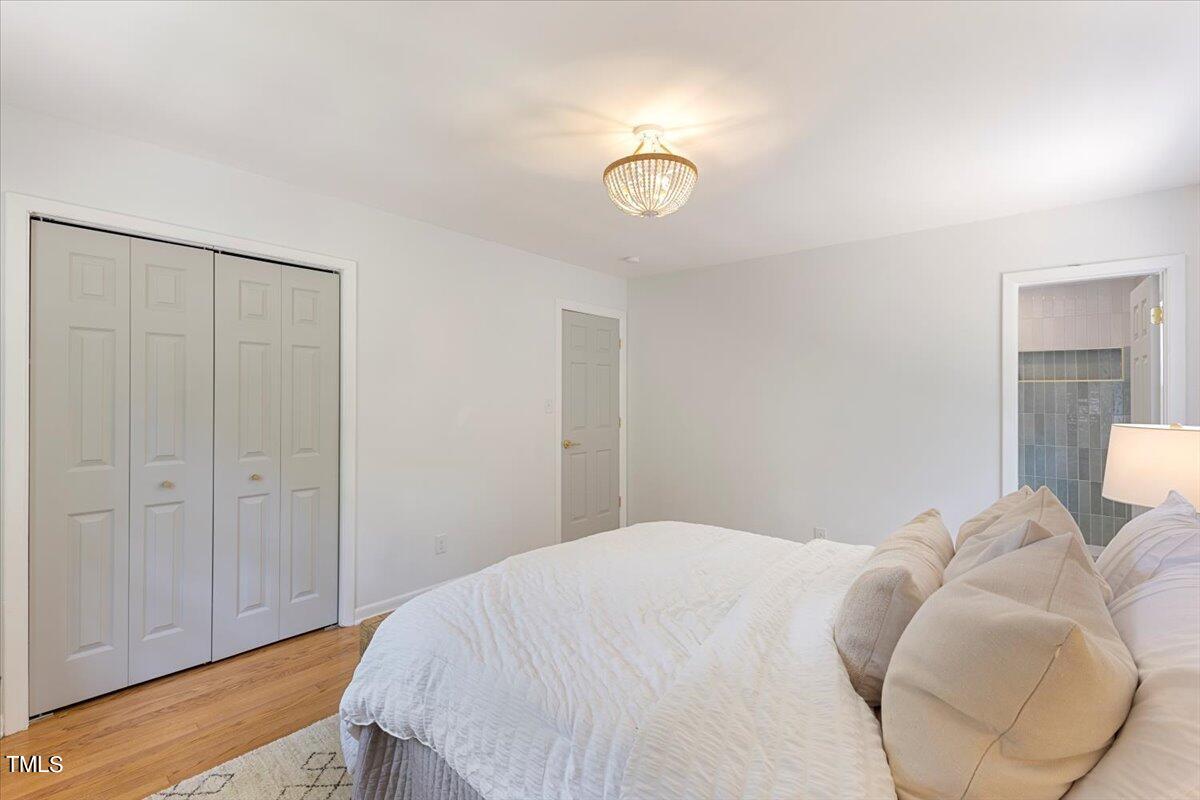 134 Radcliff Circle Durham, NC 27713 - Photo 18 of 37 a bedroom with a bed and a chandelier