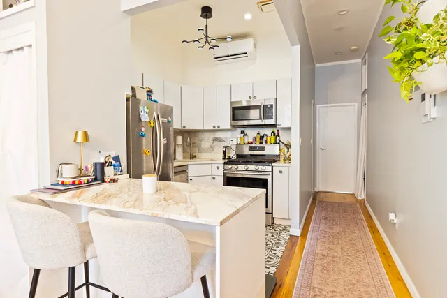 a kitchen with stainless steel appliances kitchen island granite countertop a refrigerator a stove and a sink