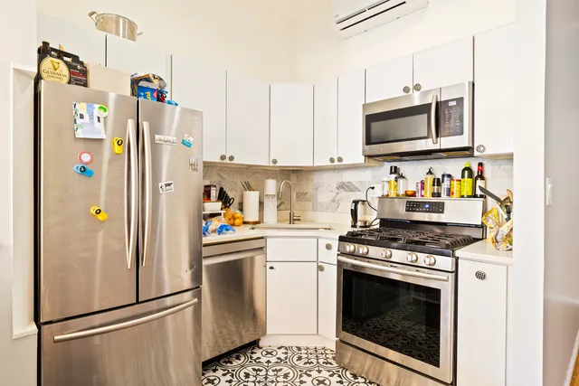 a kitchen with stainless steel appliances a stove a microwave and a refrigerator