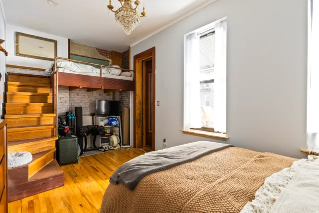 a bedroom with a bed and a chandelier