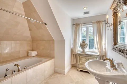 a bathroom with a tub sink and mirror