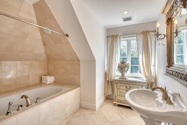 a bathroom with a tub sink and mirror