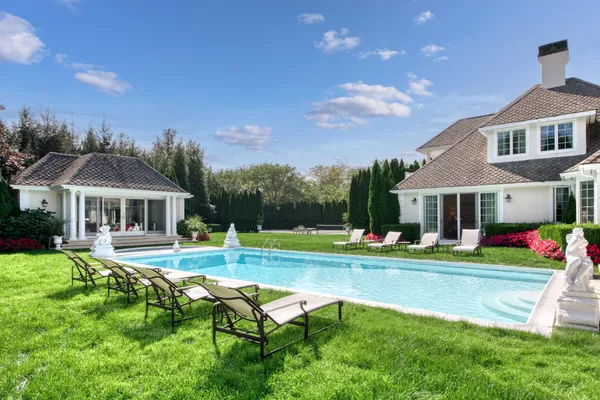 a view of a house with swimming pool and sitting area