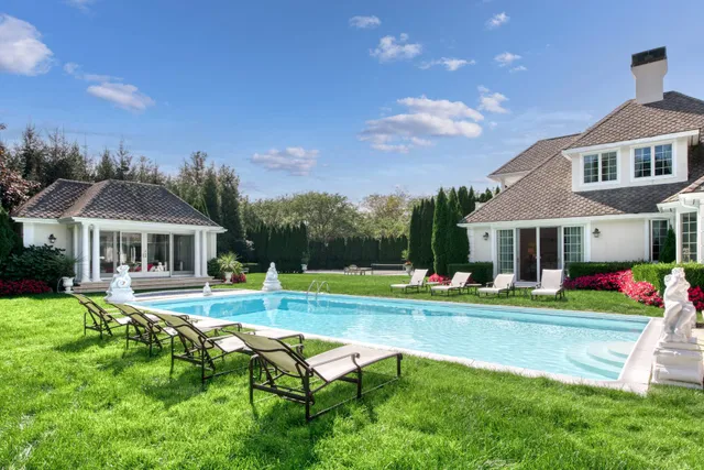 a view of a house with swimming pool and sitting area