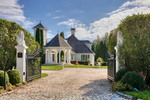 a front view of a house with a yard and potted plants