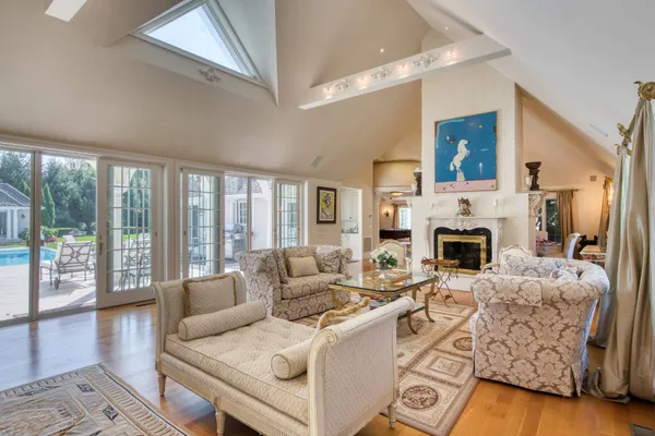 a living room with furniture a fireplace and a floor to ceiling window