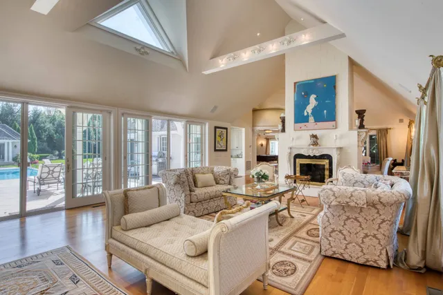 a living room with furniture a fireplace and a floor to ceiling window