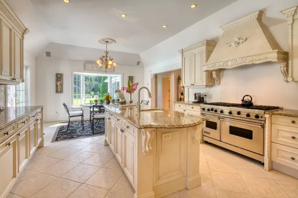 a kitchen with stainless steel appliances granite countertop a stove and a white cabinets