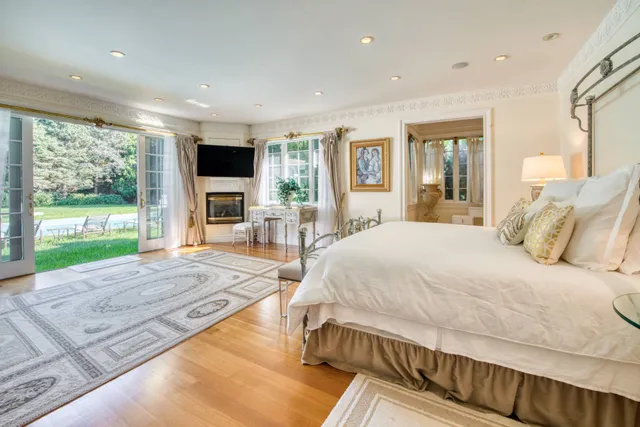 a spacious bedroom with a large bed and a flat screen tv