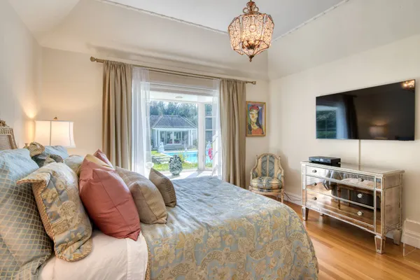 a bedroom with a bed and a flat tv screen on the dresser