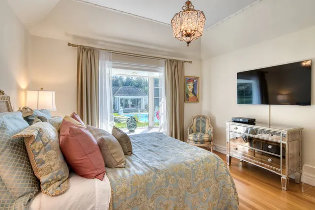 a bedroom with a bed and a flat tv screen on the dresser