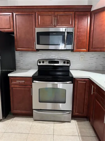 a kitchen with granite countertop a stove and a microwave
