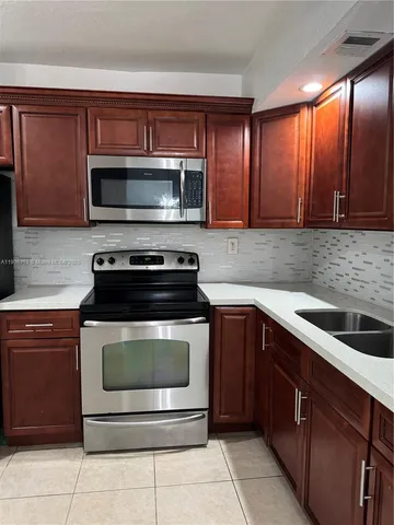 a kitchen with a sink stove and microwave