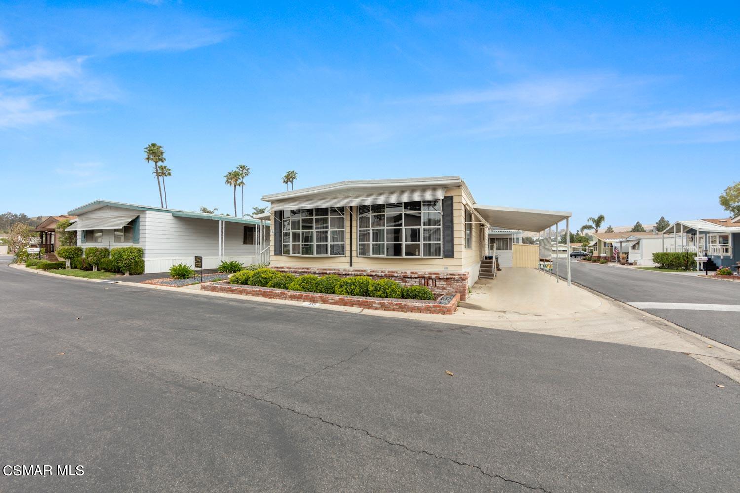 195 Tierra Rejada Road, Unit 157 Simi Valley, CA 93065 - Photo 3 of 27 a front view of a house with a yard and garage