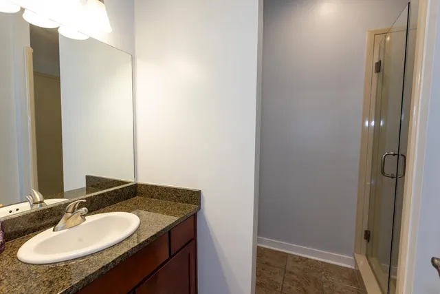 a bathroom with a granite countertop sink and a mirror