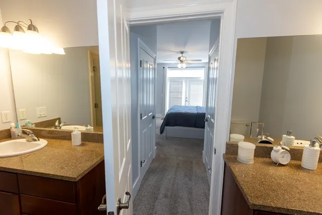 a en suite bathroom with a granite countertop sink and a mirror