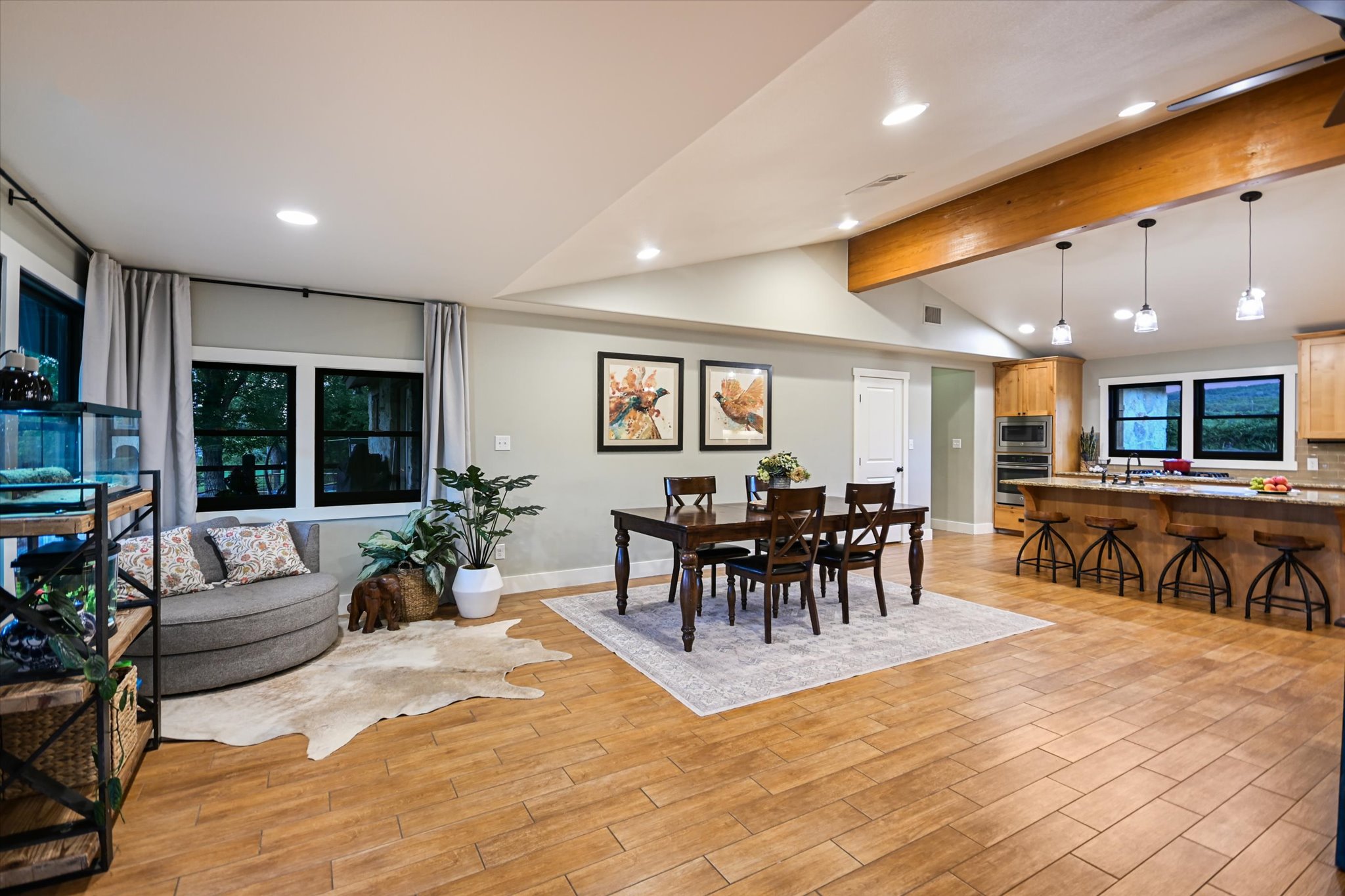 2411 Spoke Hollow Road Wimberley, TX 78676 - Photo 10 of 37 An open-concept living space with warm wood flooring and a luminous kitchen.