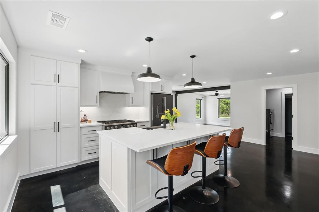 1189 West Jeter Road Bartonville, TX 76226 - Photo 5 of 40 a kitchen with stainless steel appliances granite countertop a stove a refrigerator a kitchen island a dining table and chairs with wooden floor