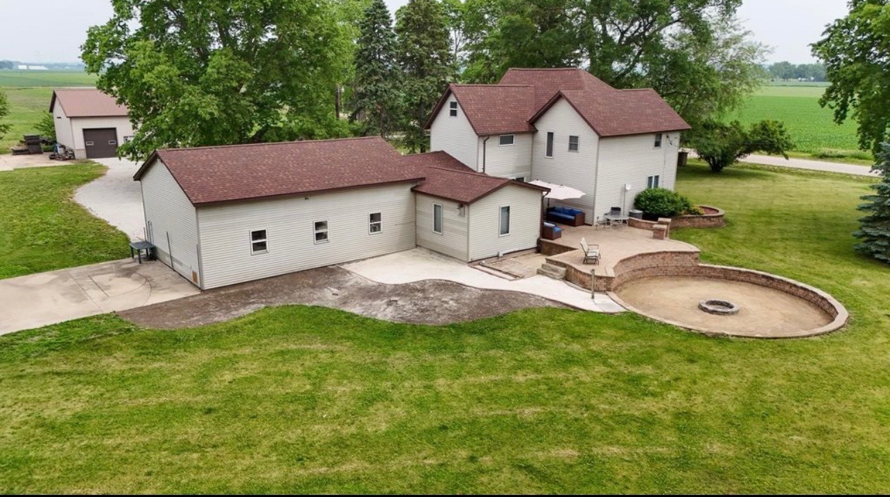 382 Keigwin Road Walnut, IL 61376 - Photo 18 of 49 a aerial view of a house with table and chairs under an umbrella