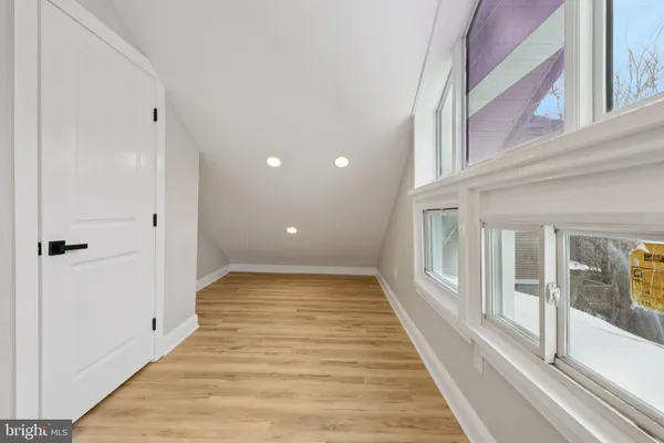 a view of a hallway with wooden floor and staircase