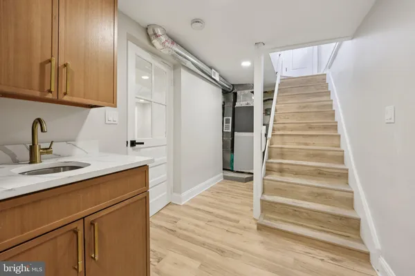 a kitchen with white cabinets and sink