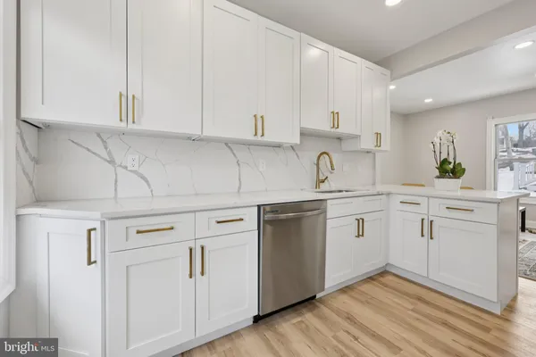 a kitchen with white cabinets appliances and sink