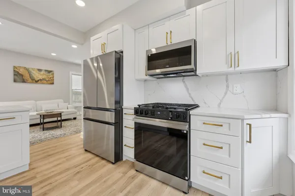 a kitchen with stainless steel appliances white cabinets and a stove top oven