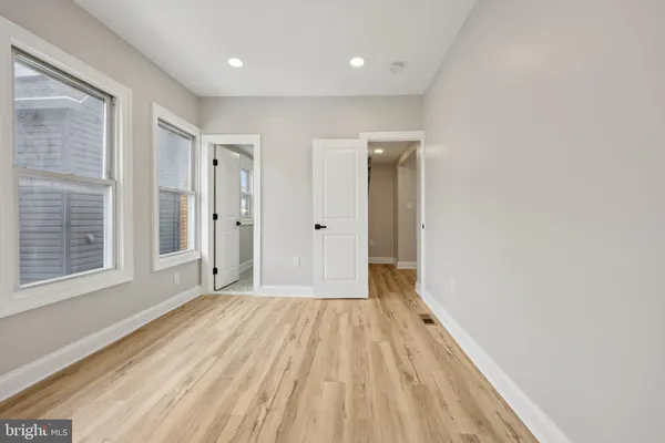 a view of a room with wooden floor and a bathroom
