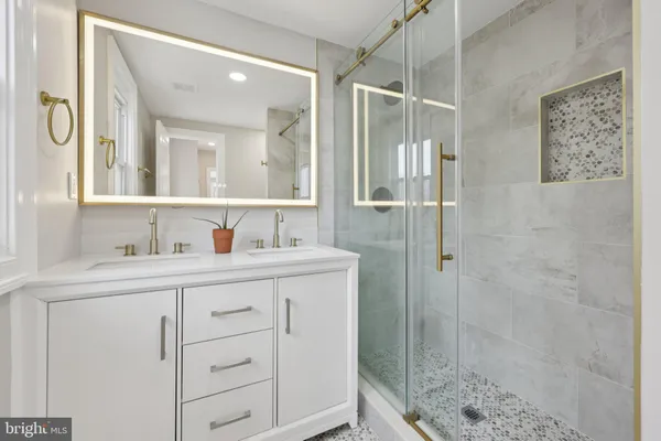 a bathroom with a shower sink and mirror
