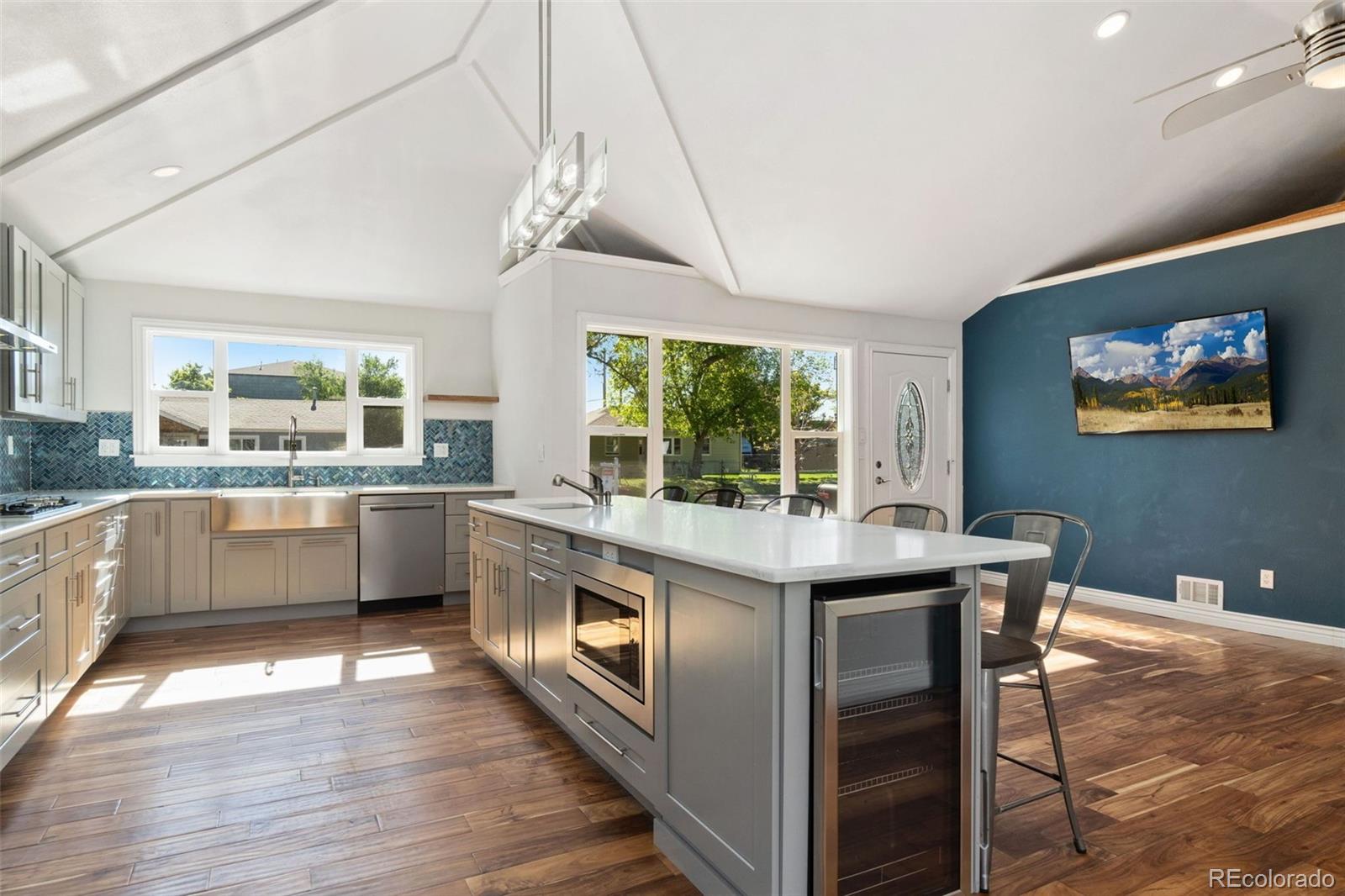 4545 Ingalls Street Wheat Ridge, CO 80033 - Photo 14 of 30 a kitchen with stainless steel appliances granite countertop a sink and wooden floors