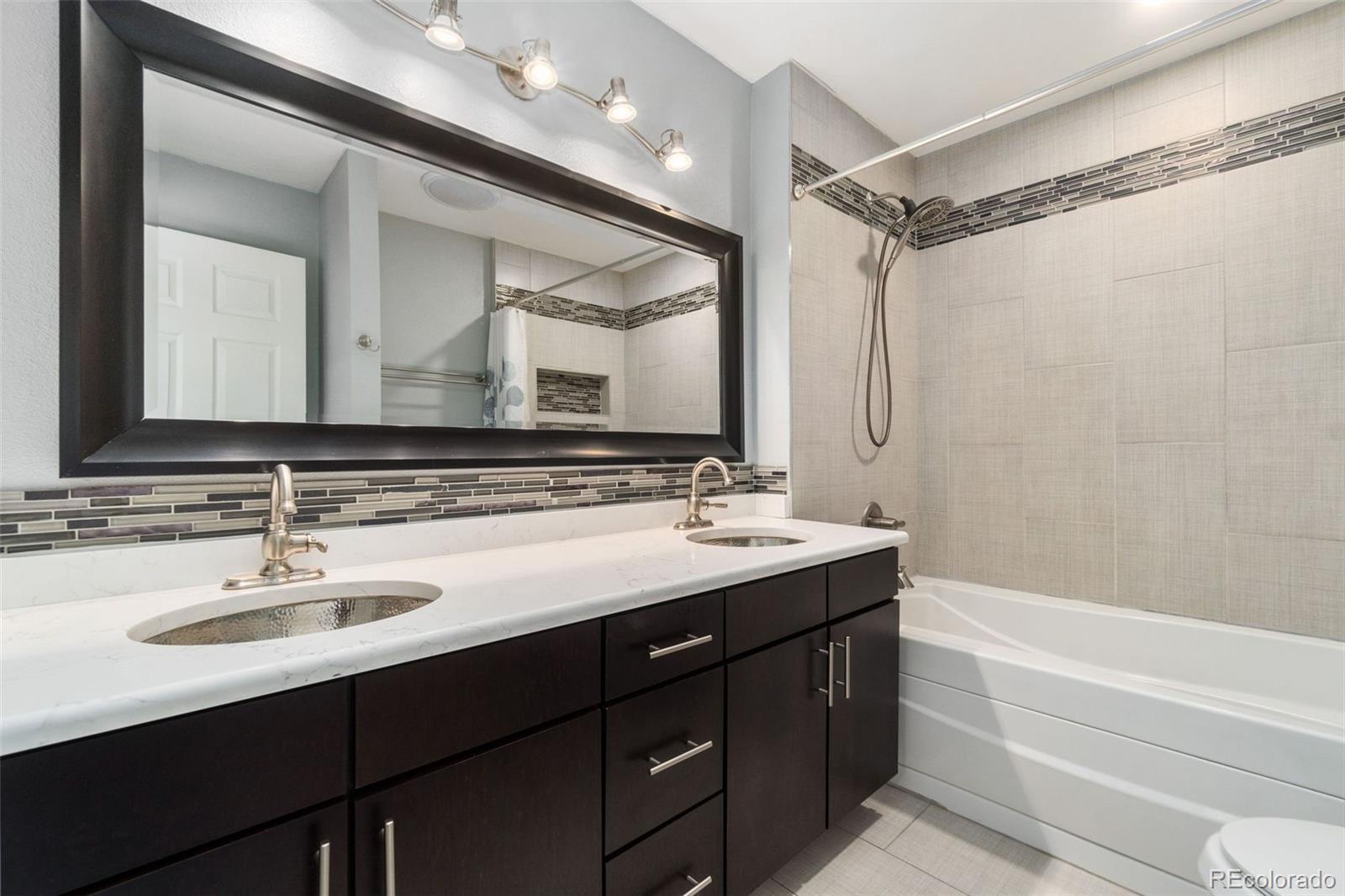 4545 Ingalls Street Wheat Ridge, CO 80033 - Photo 22 of 30 a bathroom with a sink vanity tub and a mirror