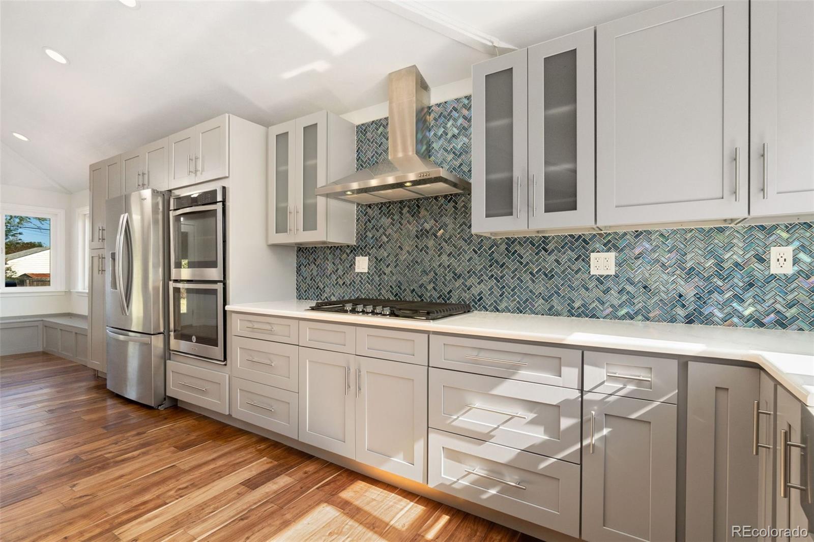 4545 Ingalls Street Wheat Ridge, CO 80033 - Photo 6 of 30 a kitchen with stainless steel appliances granite countertop a sink and cabinets with wooden floor
