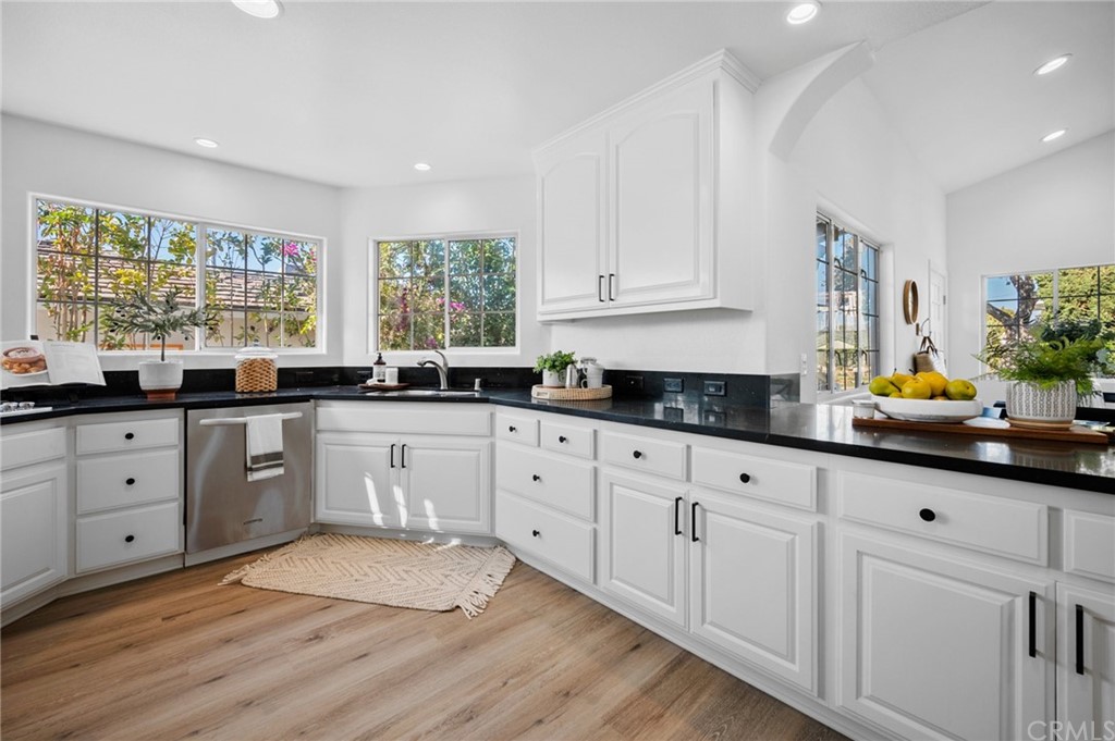101 Esplanade San Clemente, CA 92672 - Photo 13 of 54 a kitchen with stainless steel appliances granite countertop white cabinets sink and large window