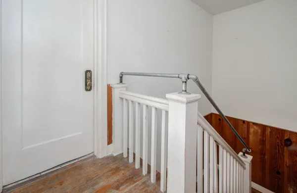 a view of a hallway with wooden floor and entryway