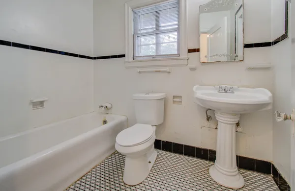 a bathroom with a sink toilet a mirror and bathtub