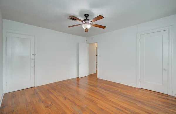 a view of an empty room with wooden floor