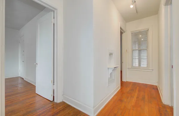 a view of a room with wooden floor and entryway