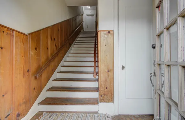 a view of a hallway with wooden floor and entryway