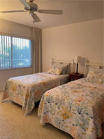 a bedroom with two beds and a chandelier