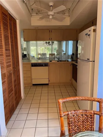 a kitchen with granite countertop a refrigerator and a stove top oven