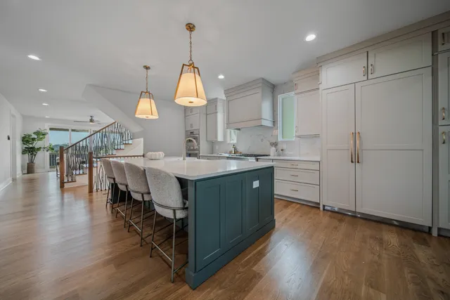 a kitchen with a stove center island a sink stainless steel appliances and cabinets