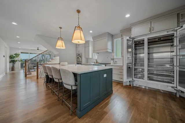a kitchen with sink a stove and a wooden floor