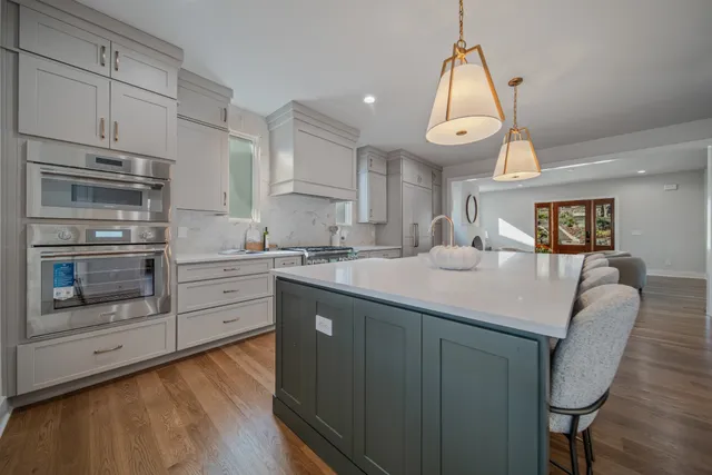 a living room with furniture two windows and a fireplace