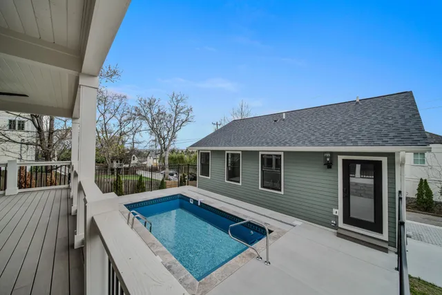 a view of an empty room with wooden floor and a ceiling fan