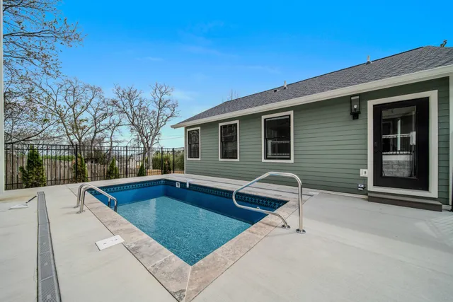 an empty room with wooden floor chandelier fan and windows