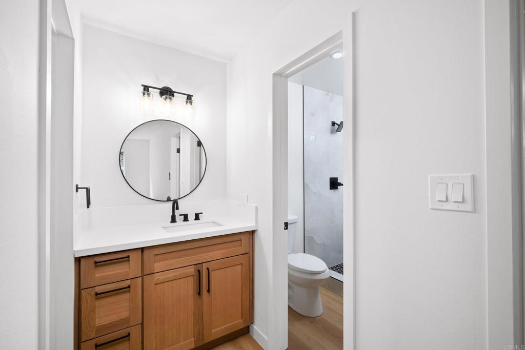 6775 Alvarado Road, Unit 26 San Diego, CA 92120 - Photo 22 of 24 a bathroom with a toilet a sink a mirror and a shower